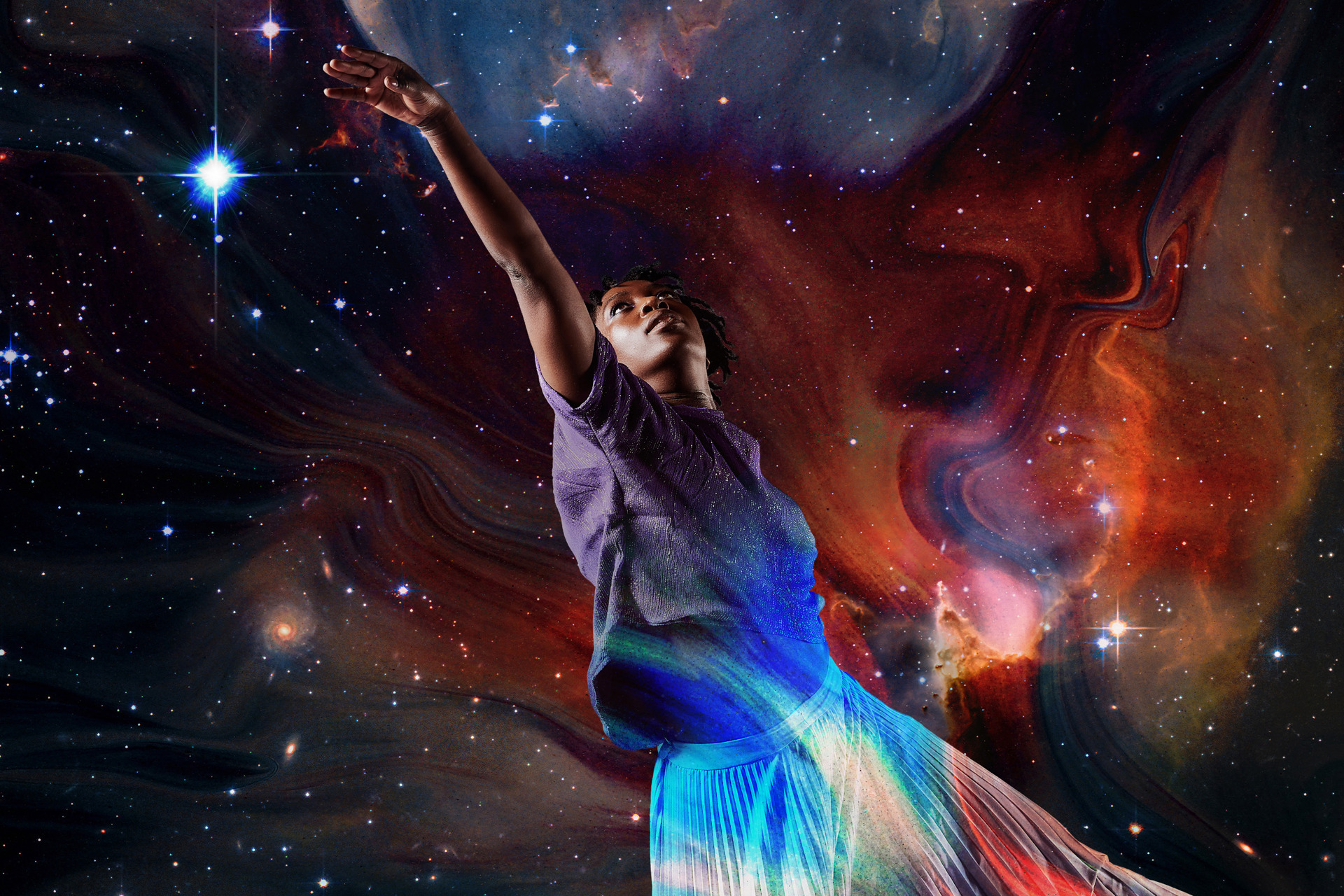 Global majority female dancer reaching to the top left on the image with a superimposed background of the galaxy 