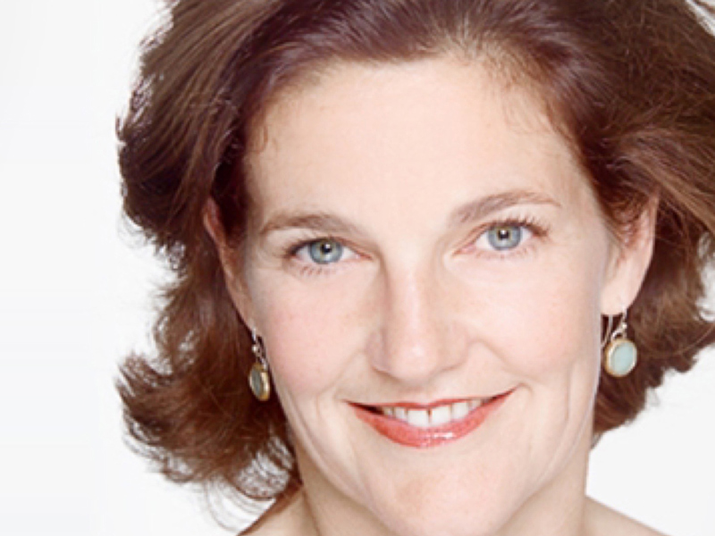 Headshot of Amanda Skoog. White female with short brown hair wearing hanging circle earrings.