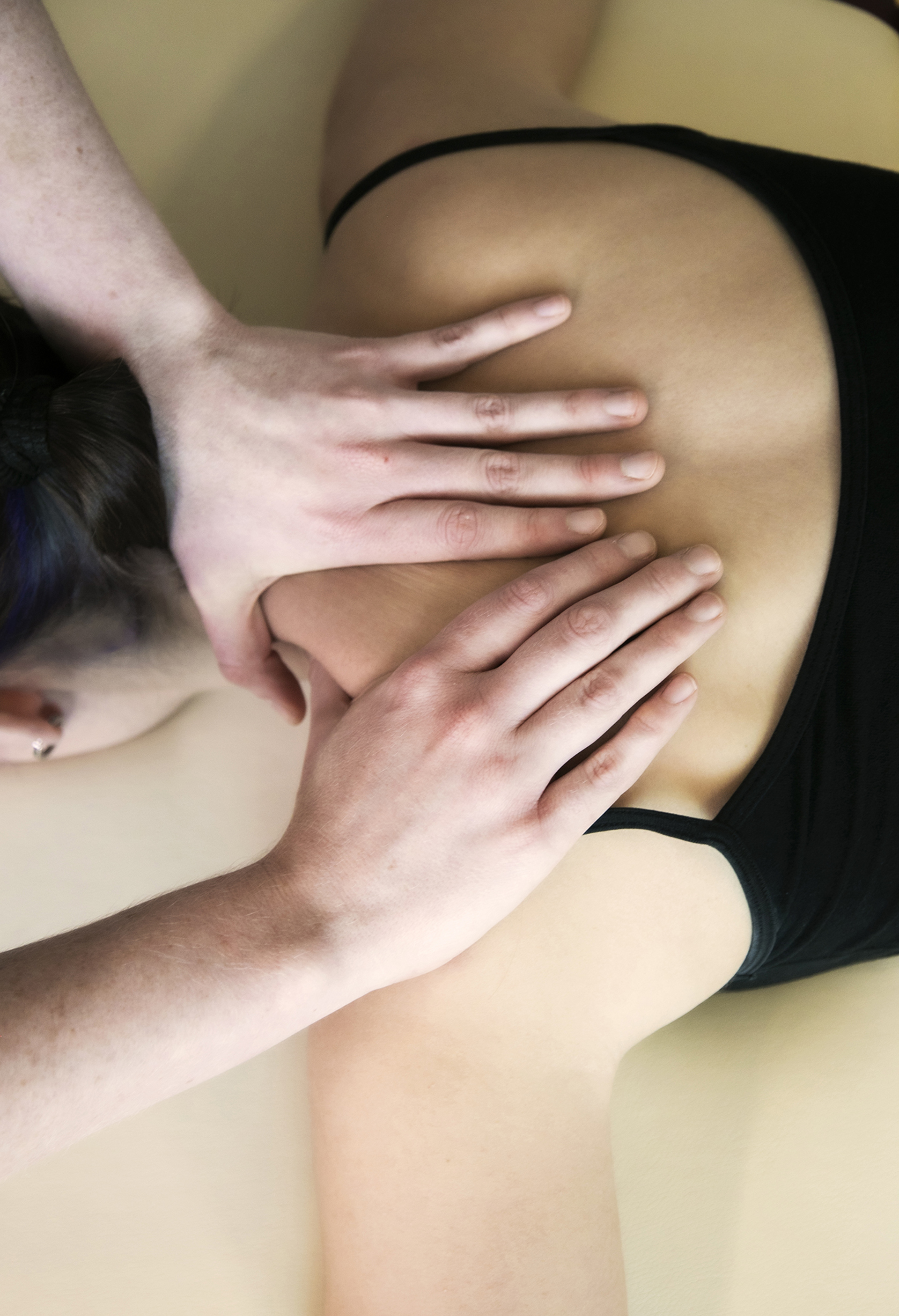 Close up of healthcare practitioners hands massaging dancers sholder