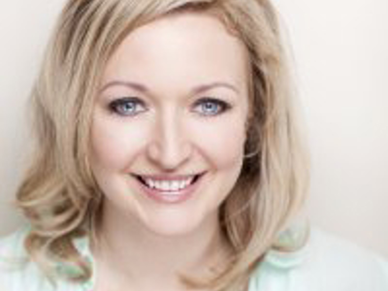 Headshot of Melodie Squire. White blonde female smiling at the camera wearung light green shirt