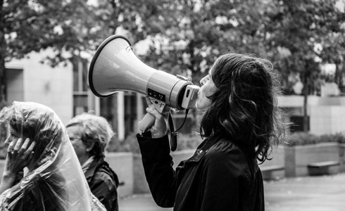 Black and white image of a person using a megaphone 