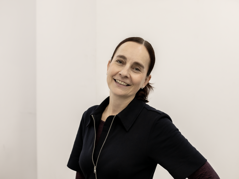 Image of Sam Lane, a woman with brown hair smiling at the camera